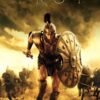 Troy movie poster featuring a Greek warrior in bronze armor holding a large shield on a battlefield.